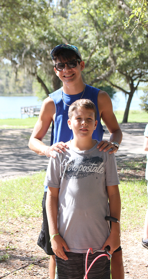 counselor and camper standing. Hands on shoulders
